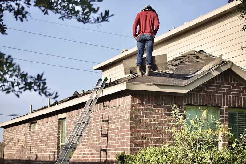 Professional roofer working on a residential roof in Macomb